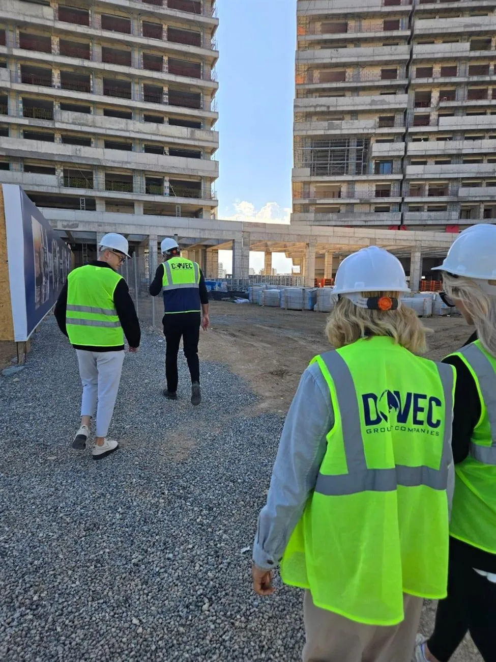 Team mit Bauhelmen und Warnwesten begutachtet eine Hochhaus-Baustelle in Nordzypern